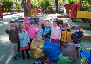 Zdjęcie dzieci z grupy I Motylki z workami pełnymi śmieci znalezionych w naszym ogrodzie przedszkjolnymj.,